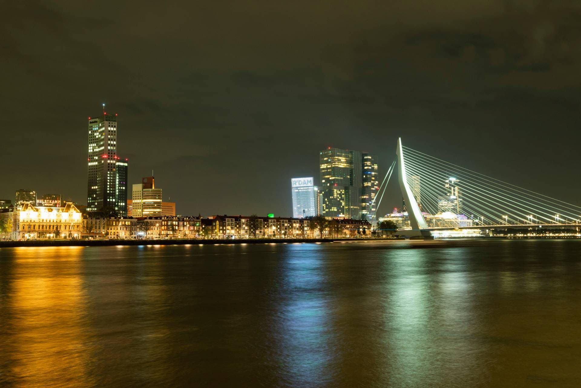De skyline van Rotterdam bij nacht met de Erasmusbrug